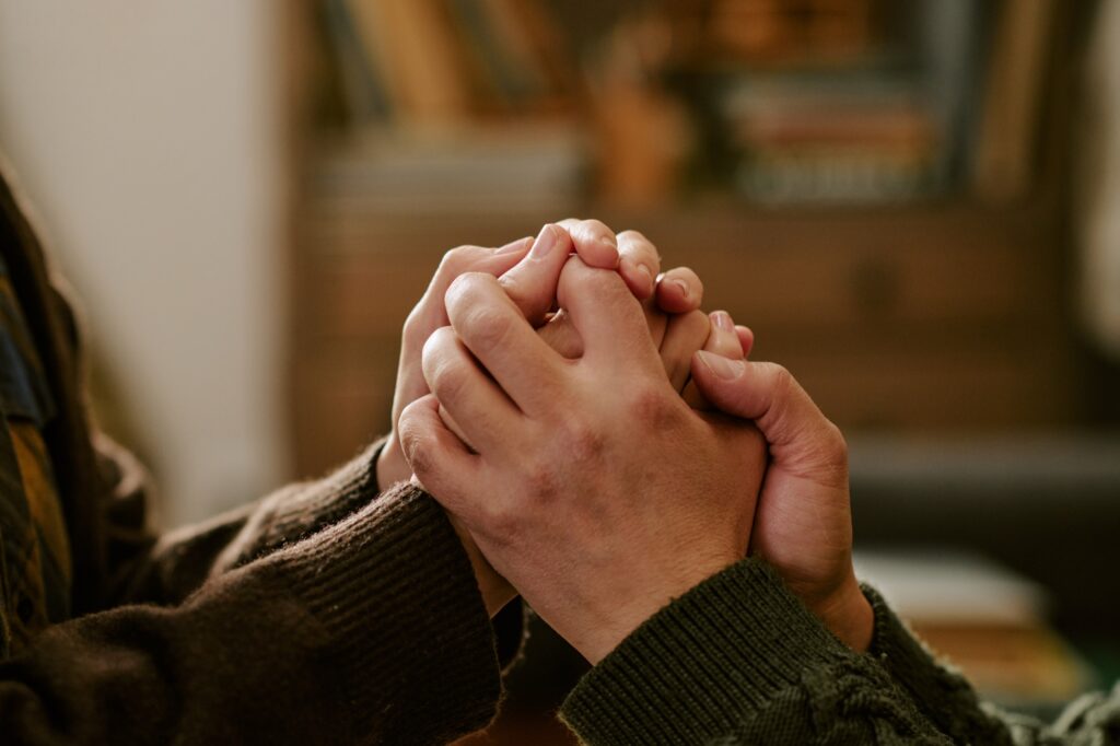Close up of young adult couple holding hands
