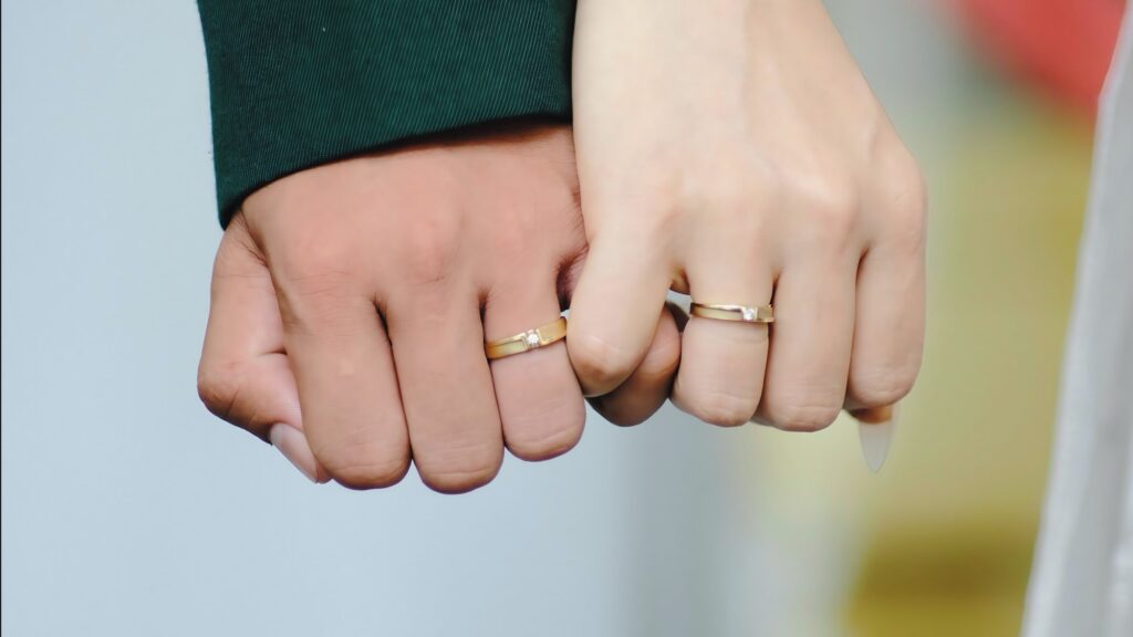 Close-up of Married Couple Joining Pinky Fingers with Rings